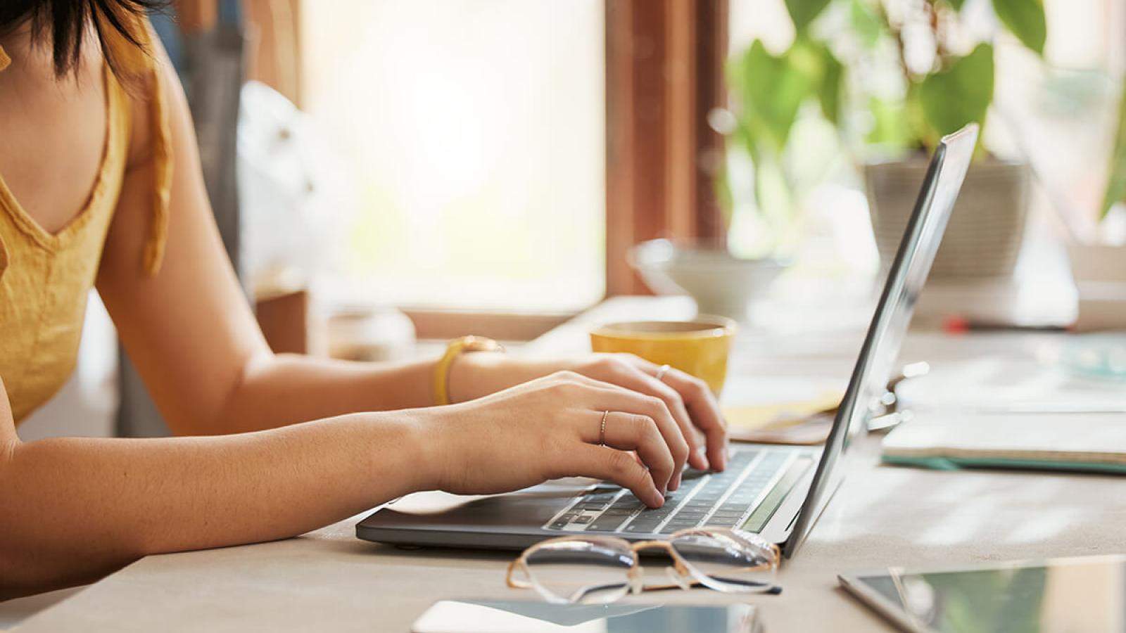 student typing on a laptop